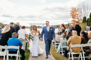 couple walking down the isle holding hands in an outdoor wedding
