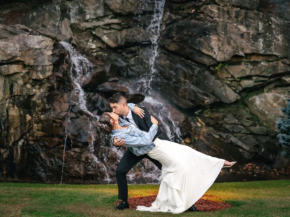 Austin dips erica and kisses her in front of a small waterfall