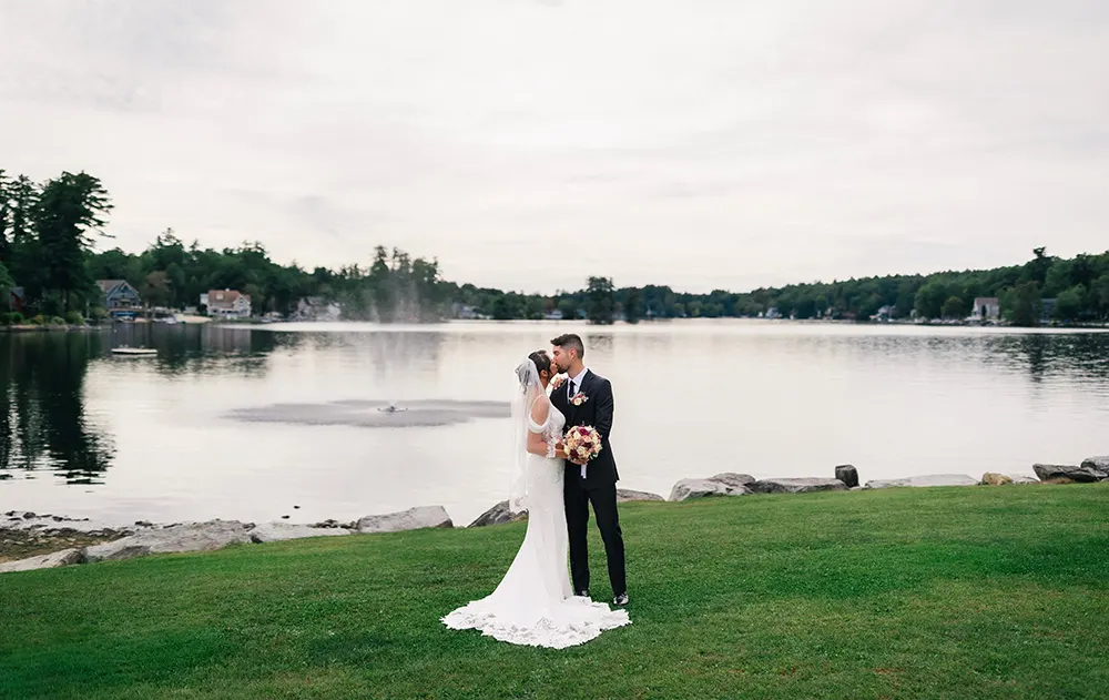 Erica & Austin kissing by the lake at Castleton